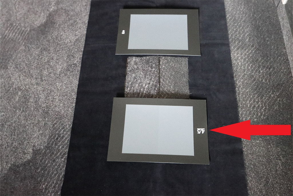 Bewertung von Farbabweichungen in einer textilen Fußbodenausstattung nach den definierten Abstufungen des großformatigen Graumaßstabs.